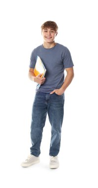 Beyaz arka planda defterleri olan tatlı bir genç çocuk.