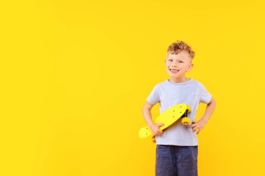 Sarı arka planda bozuk para tahtası olan küçük çocuk, mesaj için boşluk