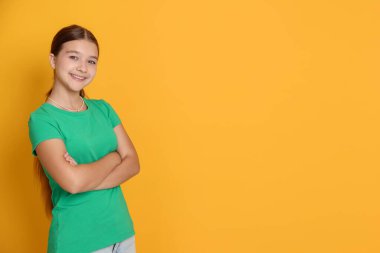 Turuncu arka planda genç bir kızın portresi, mesaj için boşluk