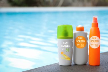 Güneş kremleri havuz kenarında şişelerde. Güneş koruma ürünü
