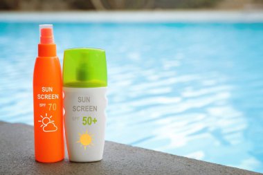 Güneş kremleri havuz kenarında şişelerde. Güneş koruma ürünü