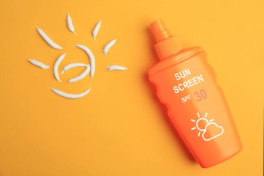 Şişede güneş kremi ve turuncu arka planda güneş koruyucu krem.