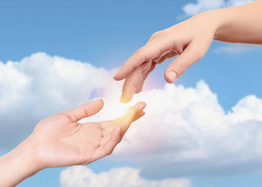 Umut. Mavi gökyüzüne karşı bulutlarla el ele tutuşan kadınlar, yakın çekim.