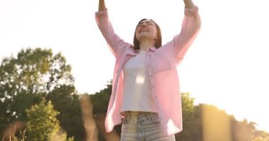 Özgürlüğü hissetmek. Mutlu genç bir kadın doğanın tadını çıkarıyor. Kamera hareket ediyor