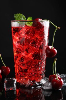 Buzlu vişneli gazoz, böğürtlen ve nane şekerli siyah arka plan, yakın plan.