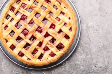 Gri desenli masada vişneli turta, üst manzara.