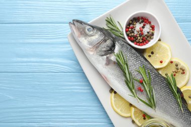 Mavi ahşap masadaki baharatlı taze çiğ deniz kabuğu balığı, üst manzara ve yazı için yer. Deniz ürünleri lezzetleri.