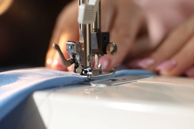 Bulanık koyu arkaplan, makro görünüm üzerinde dikiş makinesiyle çalışan kadın