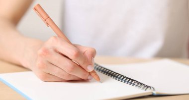 Not defterine kalemle yazı yazan kadın, yakın plan