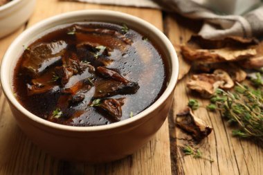 Mantarlı lezzetli çorba ve ahşap masada kekik, yakın plan.