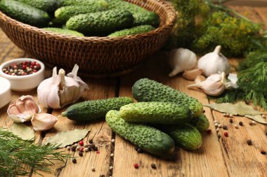 Turşu yapıyorum. Taze salatalıklar ve diğer malzemeler ahşap masada, yakın plan.