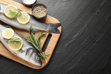 Siyah masadaki baharatlı taze çiğ deniz kabuğu balığı, üst görünüm ve metin için yer. Deniz ürünleri lezzetleri.