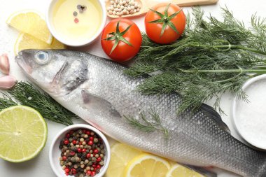 Taze çiğ deniz kabuğu ve beyaz masa üzerinde baharatlar. Balık ve deniz ürünleri lezzetleri