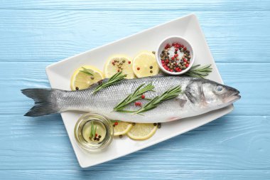 Mavi ahşap masadaki baharatlı taze çiğ deniz kabuğu. Balık ve deniz ürünleri lezzetleri