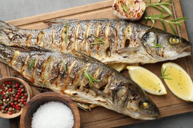 Gri masada biberiye ve limonla servis edilen lezzetli kavrulmuş deniz kabuğu balığı. Ev yapımı deniz ürünleri yemeği.