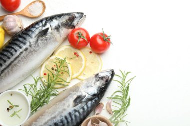 Deniz ürünleri lezzetleri. Taze çiğ uskumrular ve baharatlar beyaz masada, düz yerde. Metin için boşluk