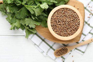 Kişniş tohumu ve taze kişniş beyaz ahşap masa, üst manzara