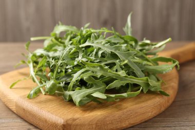 Taze yeşil roka yaprakları ahşap masada, yakın plan.