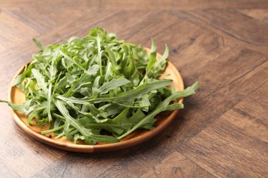 Taze yeşil roka yaprakları ahşap masada, yakın plan. Metin için boşluk