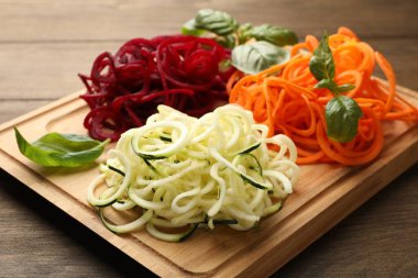 Ahşap masada fesleğenli farklı sebze erişteleri, yakın plan. Vejetaryen yemeği.