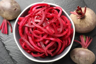 Çiğ pancar eriştesi ve taze sebzeler siyah masada, düz yerde. Vejetaryen yemeği.