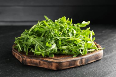 Taze yeşil roka yaprakları siyah masada, yakın plan.