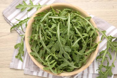 Taze yeşil roka yaprakları açık ahşap masada, düz yerde.