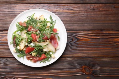 Lezzetli salata roka, prosciutto, peynir, armut, greyfurt ve ahşap masada fındık. Metin için boşluk