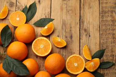 Taze olgun portakallar ve yapraklar ahşap masada, düz yerde. Metin için boşluk