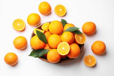 Taze taze portakallar ve beyaz arka planda yeşil yapraklar.