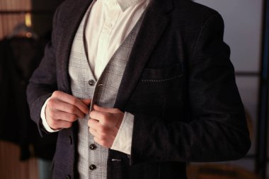 Şık giyinmiş bir adam içeride hazırlanıyor, yakın plan.