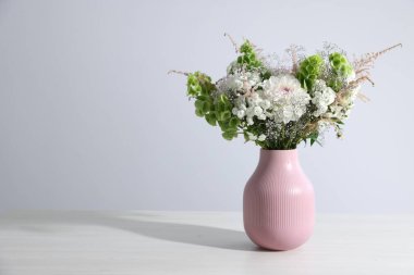 Beyaz masadaki vazoda güzel çiçekler, metin için boşluk