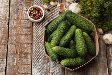 Turşu yapıyorum. Tahta masada taze salatalık ve baharat var. Metin için boşluk