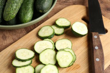 Kes ve salatalıkları ahşap masaya koy, yakın plan.