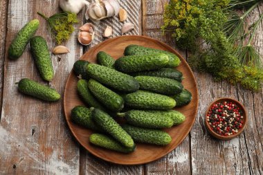 Turşu yapıyorum. Taze salatalıklar ve baharatlar ahşap masada, düz yatıyordu.