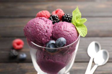 Taze böğürtlenli lezzetli şerbet ve ahşap masadaki cam tatlı kasesinde nane şekeri.