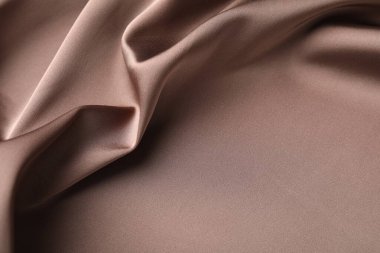 Arkaplan olarak buruşuk açık kahverengi ipek kumaş, yakın plan