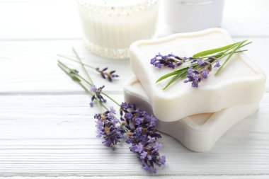 Sabun barları ve lavanta çiçekleri beyaz ahşap masada, yakın plan. Metin için boşluk