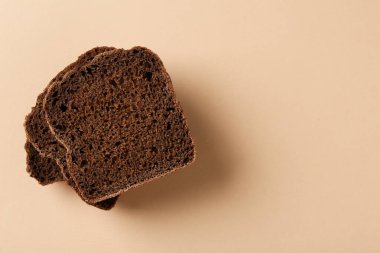 Bej arka planda taze çavdar ekmeği parçaları, üst manzara. Metin için boşluk