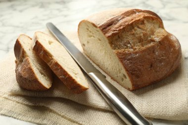 Masada taze ekmek ve bıçak parçaları, yakın plan.