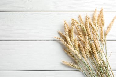 Beyaz ahşap masada bir sürü buğday çivisi var. Metin için boşluk