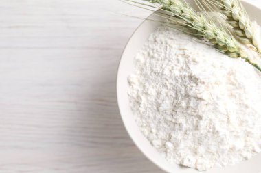 Yeşil buğday dikenleri ve un açık ahşap masa, üst manzara. Metin için boşluk