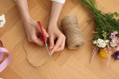 Çiçek buketi yapan bir çiçekçi, ahşap masa, üst manzara