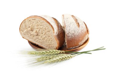 Taze ekmek parçaları ve beyaz üzerine izole edilmiş yeşil buğday başakları.