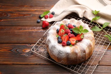Tahta masada pudra şekeri ve böğürtlenli Lezzetli kek, mesaj için yer var.