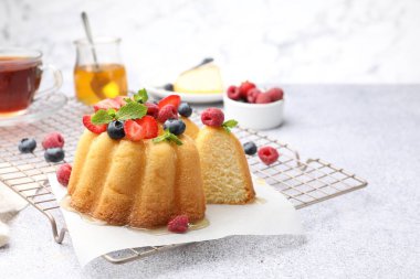 Açık gri masada böğürtlenli, ballı ve nane şekerli Lezzetli kek, yakın plan.