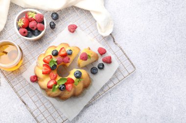 Açık gri masada böğürtlenli, ballı ve nane şekerli Lezzetli Bundt keki. Metin için boşluk