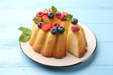 Böğürtlenli kek ve açık mavi ahşap masada nane şekeri, yakın plan.