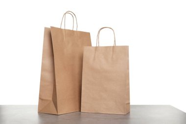 Gri masada beyaz arkaplana karşı iki kese kağıdı.