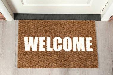 Hoş geldin paspası. Ön kapının yanında, üst tarafta.